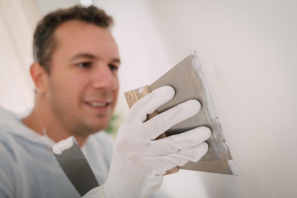 man putting putty wall